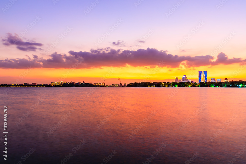 美丽的苏州城市天际线和日落时分的湖泊建筑，中国。