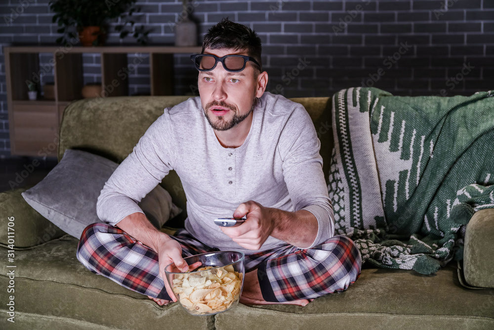 Man watching movie late in evening at home