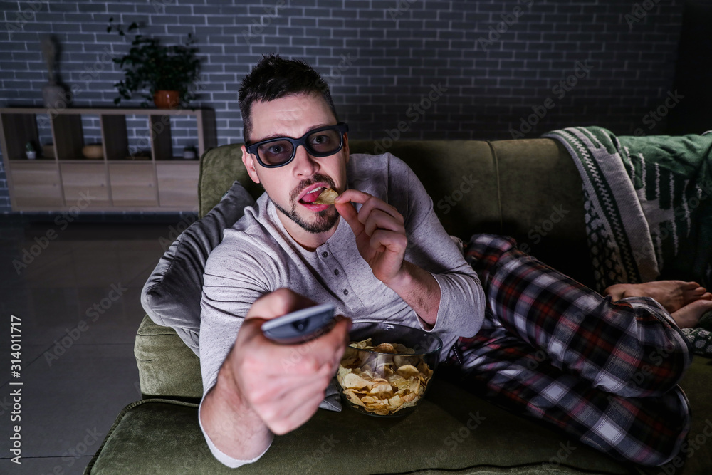 Man watching movie late in evening at home