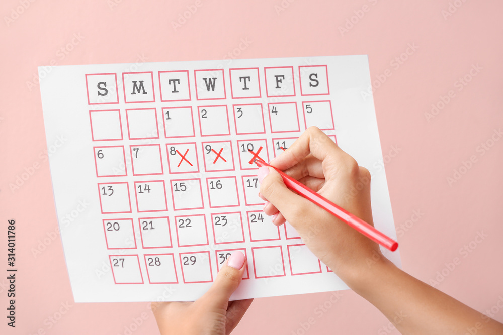 Woman with menstrual calendar on color background