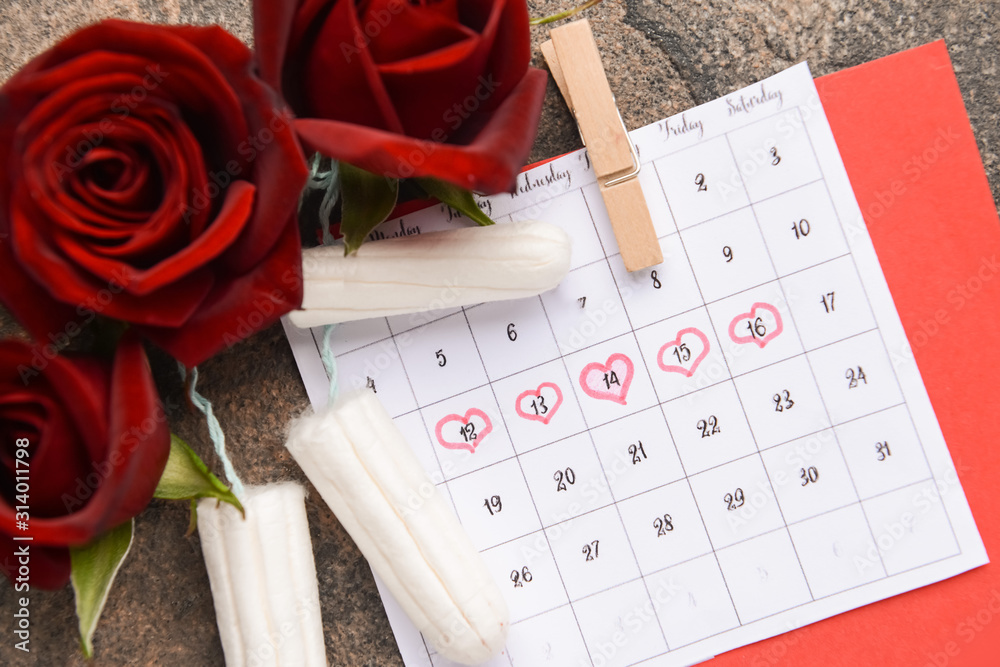 Menstrual calendar with tampons and flowers on grey background