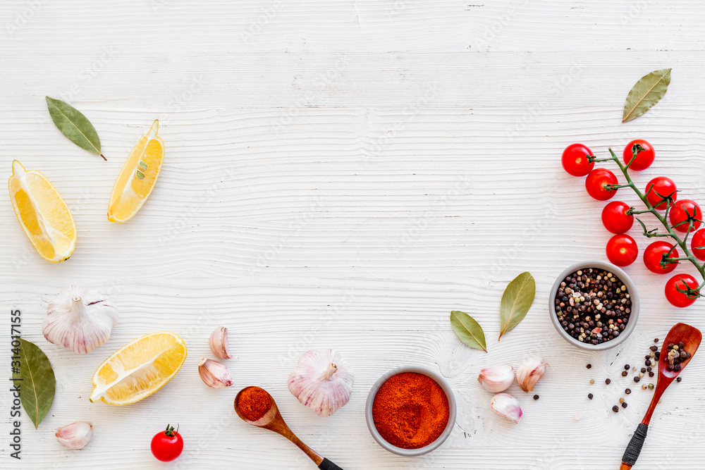 Kitchen frame with spices and food - pepper, garlic, cherry tomatoes - on white background top-down 