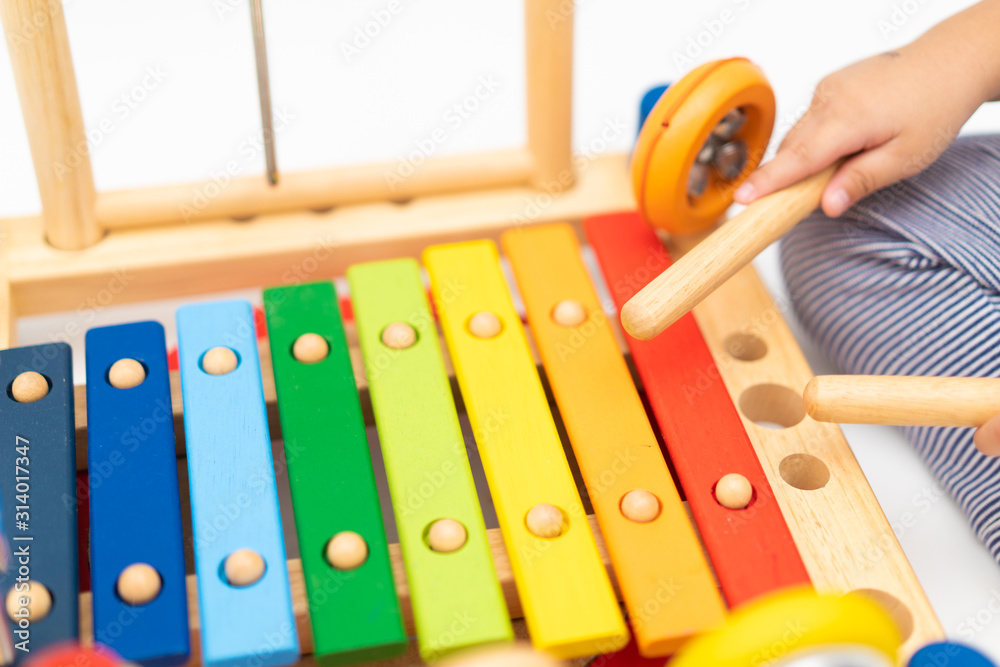 Little baby drummer boy playing percussion and hitting the drum set at home.Asian boy playing and si