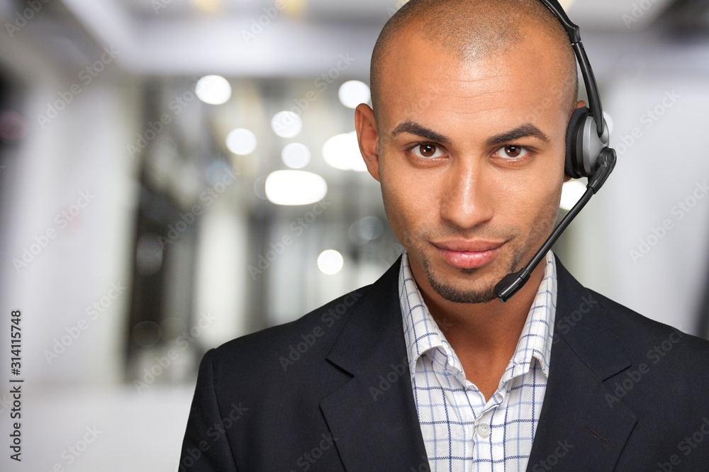 Smiling handsome businessman wearing headset looking at camera