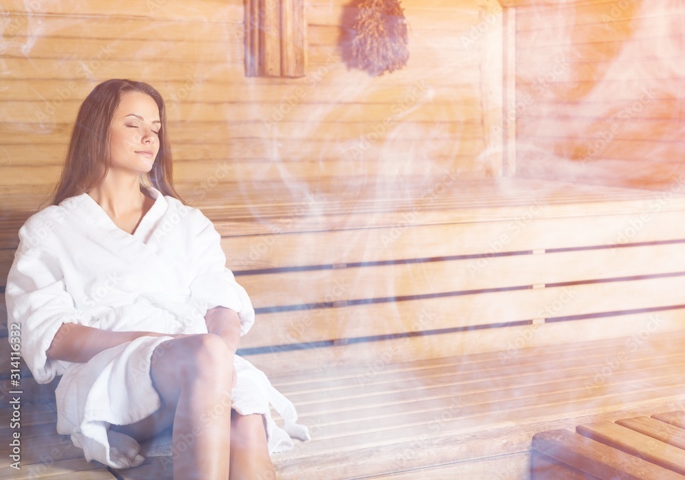 Young beautiful relaxed woman in a sauna