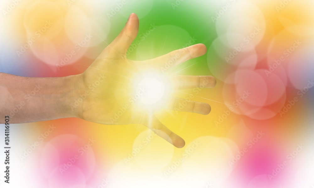 The light in young woman hands on colored blur background