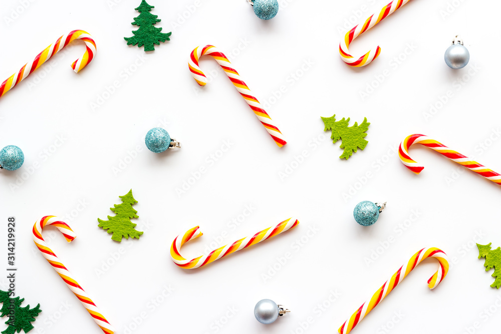 New Year background with Christmas candy cane, festive tree and balls. Pattern on white desk top-dow