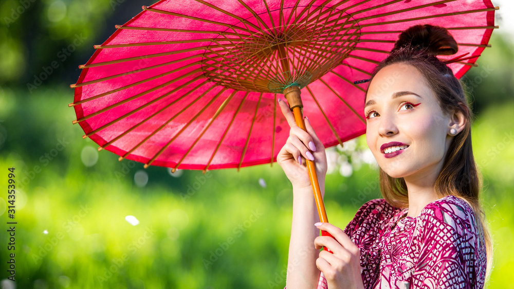 穿着和服，带着雨伞的日本女人。美丽的亚洲女孩，穿着绿色丝巾，妆容鲜艳