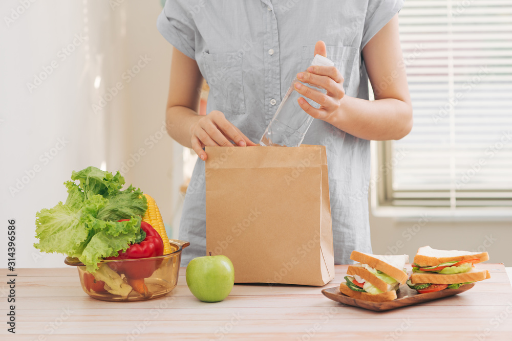 Mother cooking school lunch box set, Preparing healthy snacks - cheese sandwich, fruits and vegetabl