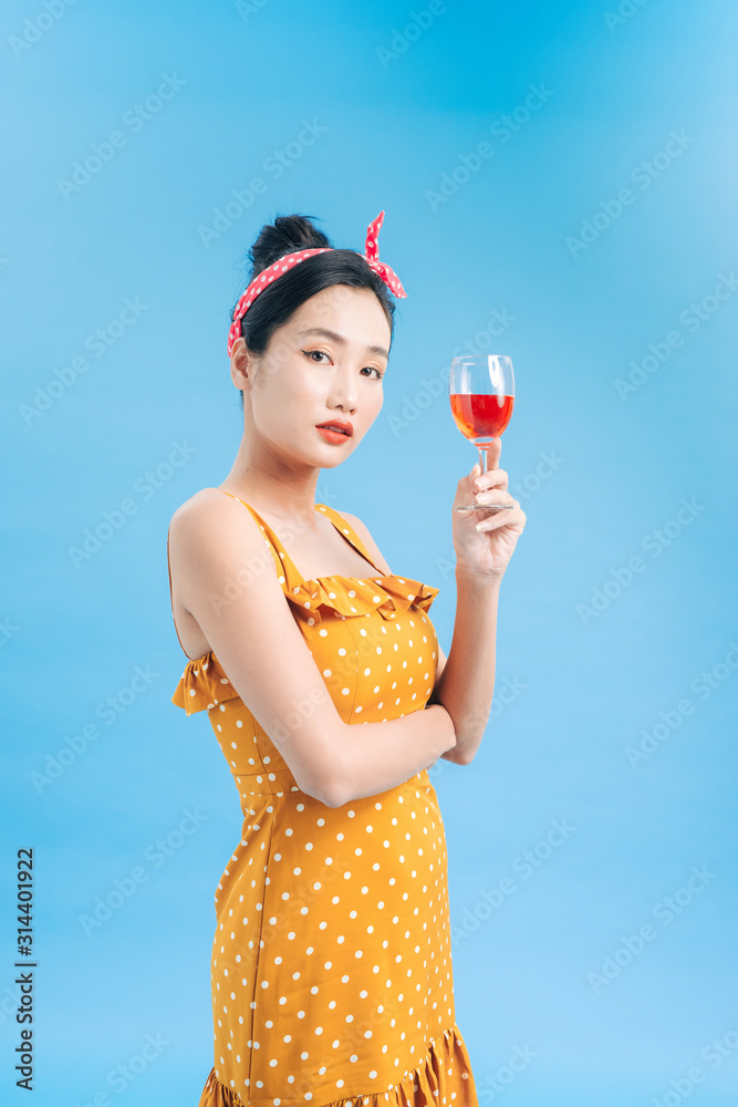 Portrait of a smiling young woman holding a glass of red wine