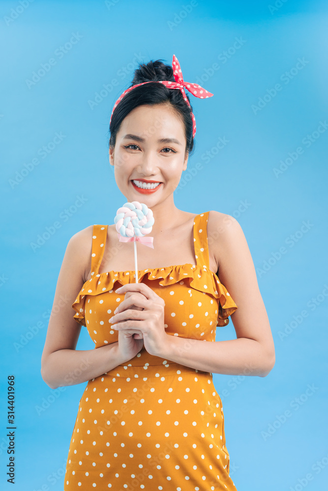 happy young woman with lollipop candy isolated on blue