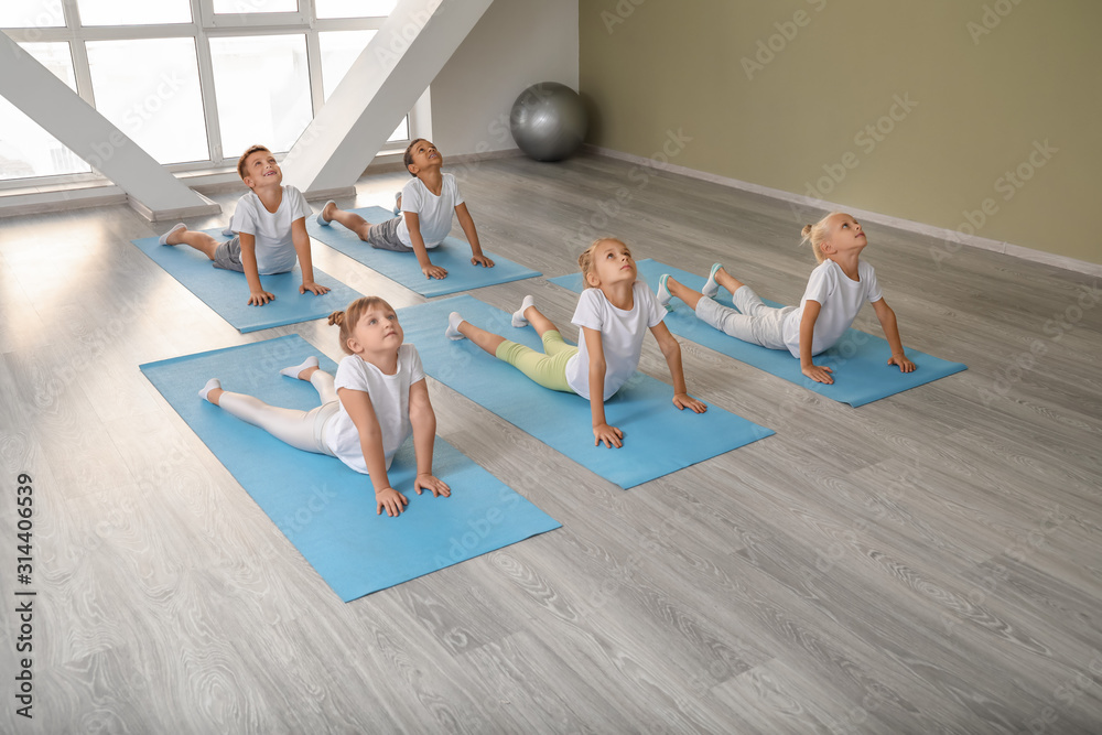 Little children practicing yoga in gym