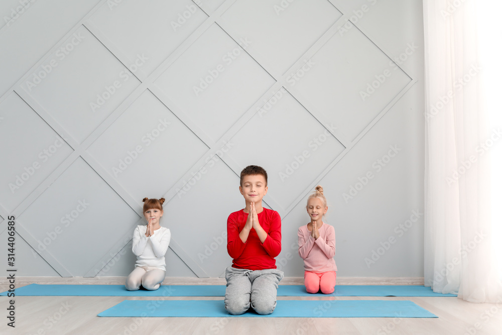 Little children practicing yoga in gym