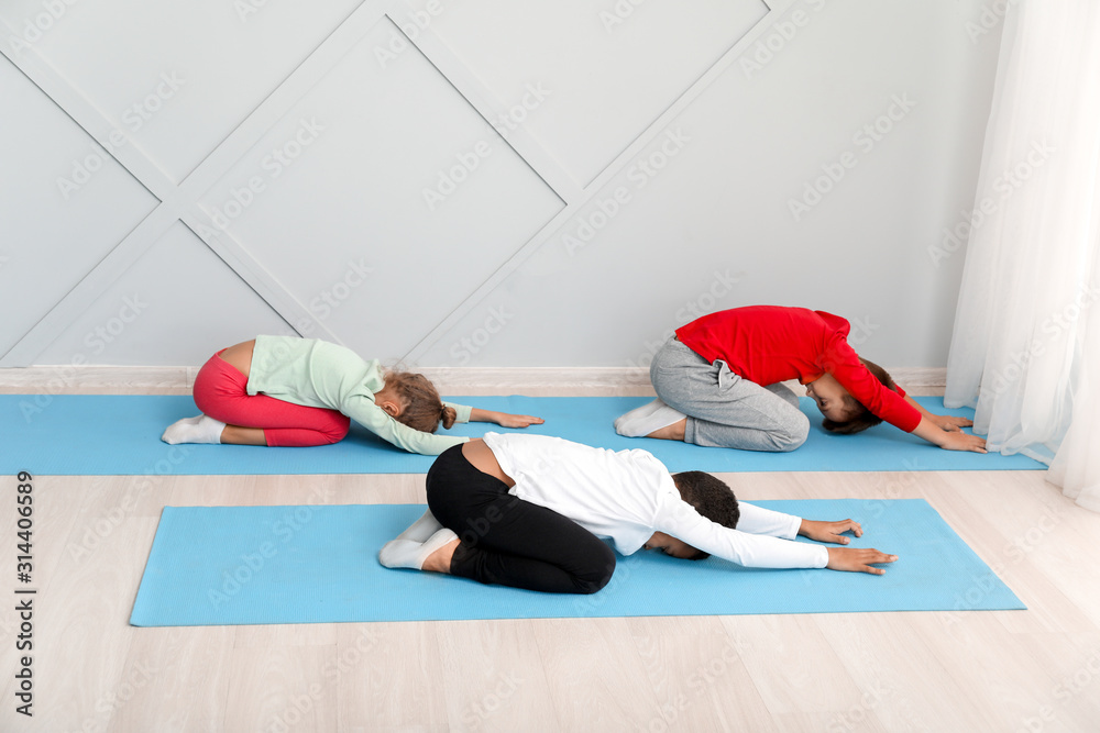 Little children practicing yoga in gym