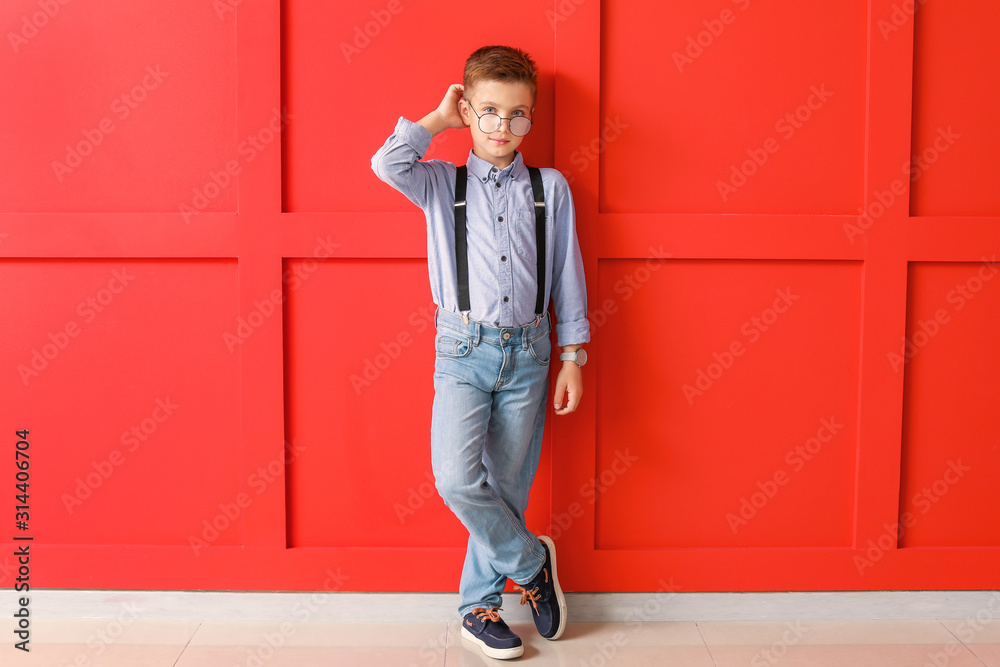 Cute fashionable boy on color background