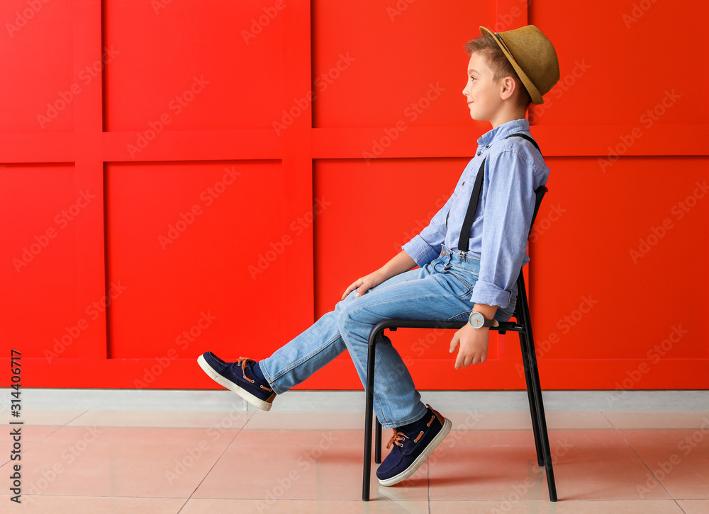 Cute fashionable boy on color background