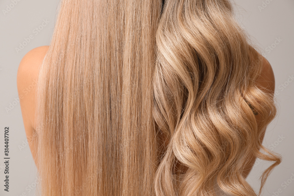 Beautiful young woman with curly and straight hair on light background, closeup