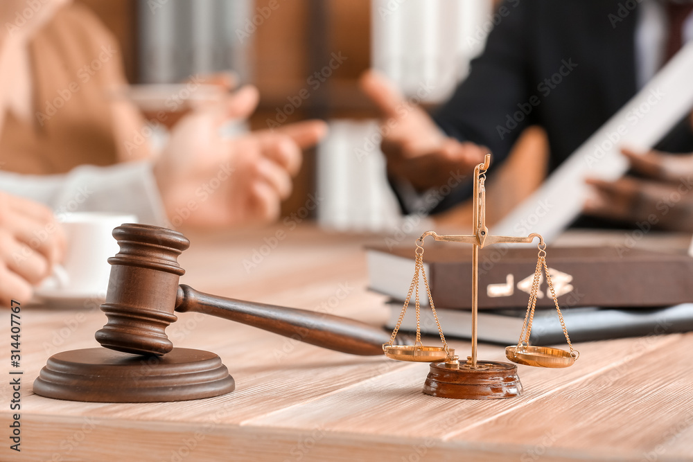 Scales of justice and gavel  on table of lawyer in office