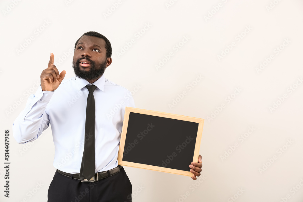 African-American teacher with chalkboard on white background