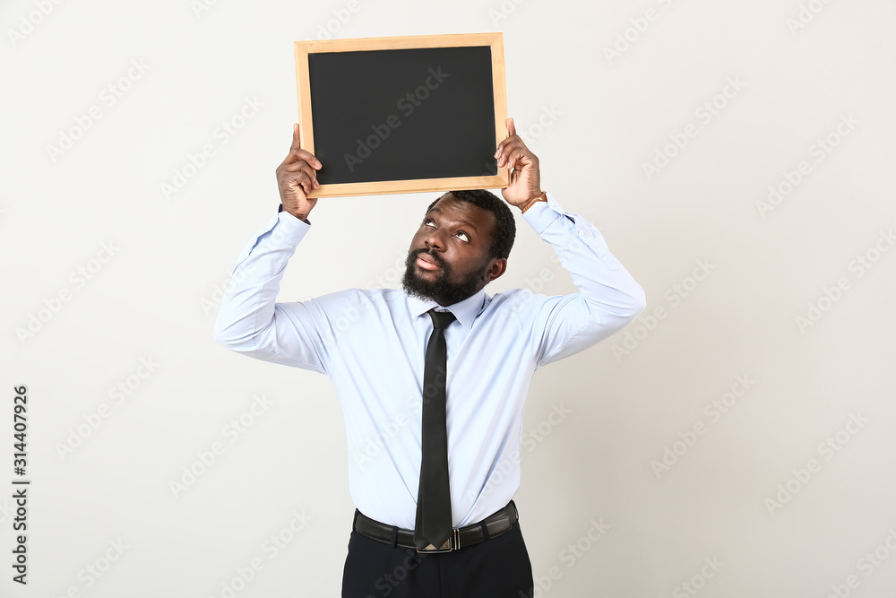 African-American teacher with chalkboard on white background