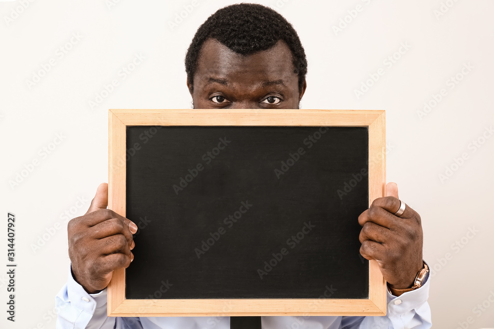 African-American teacher with chalkboard on white background