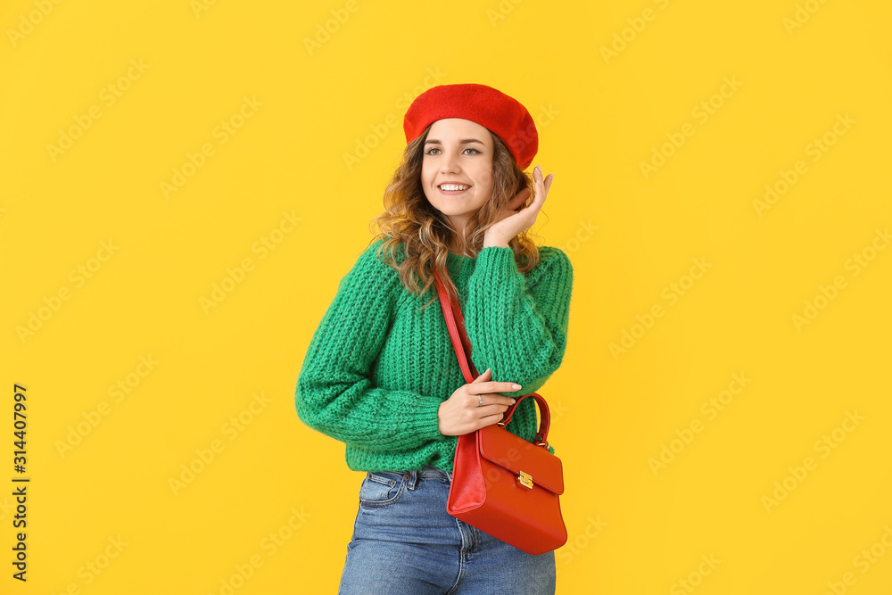 Beautiful young woman in warm sweater on color background