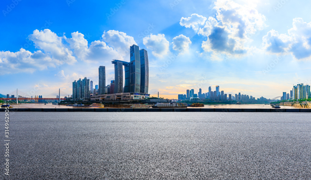 中国重庆，空旷的柏油路和建筑林立的城市天际线。