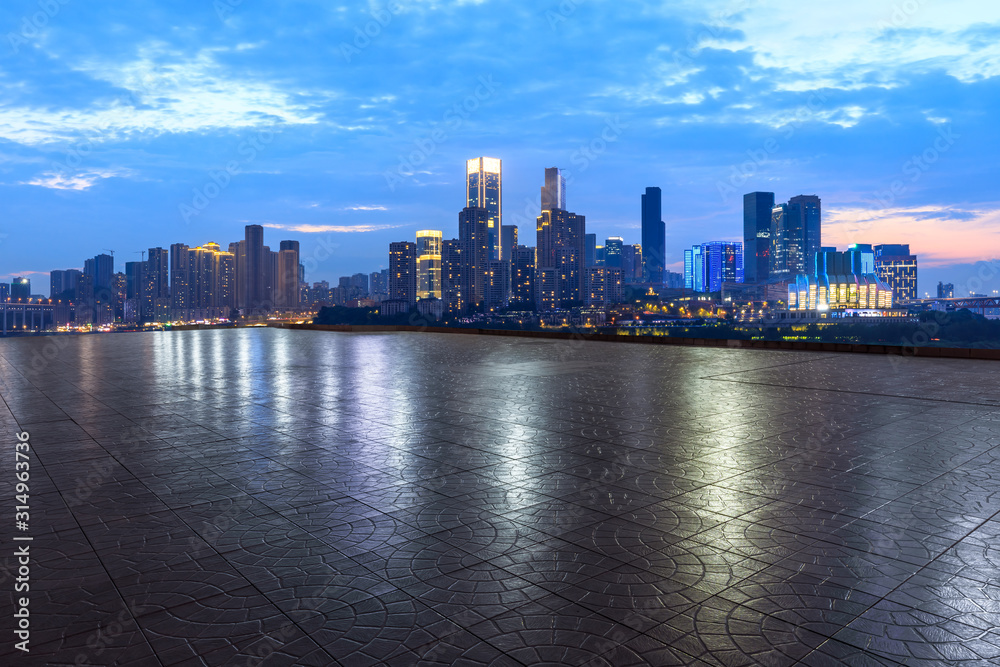 中国重庆，夜晚，空旷的广场层和城市天际线，建筑林立。