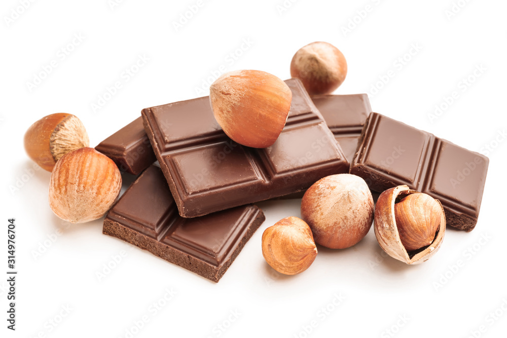 Tasty chocolate with hazelnuts on white background