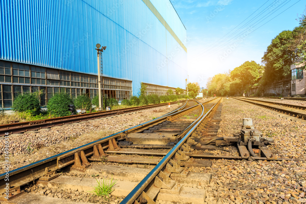 Railway passing through industrial area plant building.