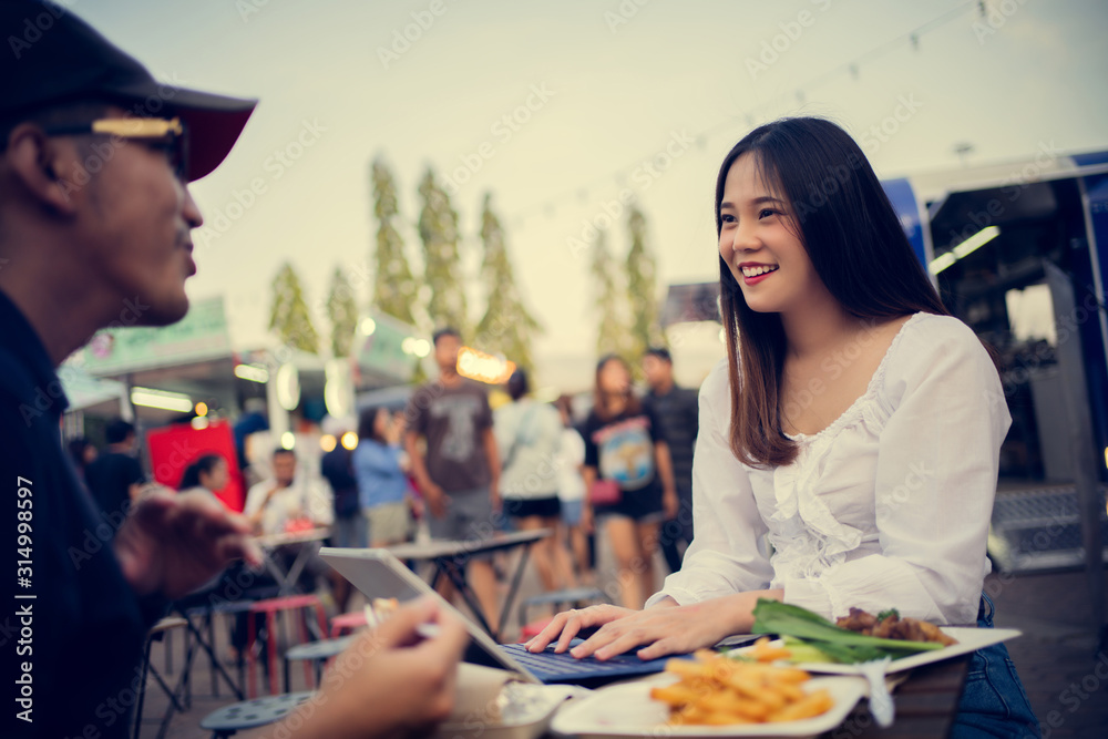 亚洲女人在吃街头食品，她在公司工作