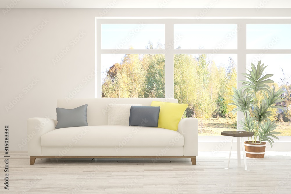 Stylish room in white color with sofa and autumn landscape in window. Scandinavian interior design. 