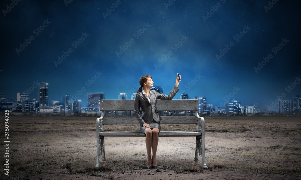 Business woman holding smartphone with raised hand