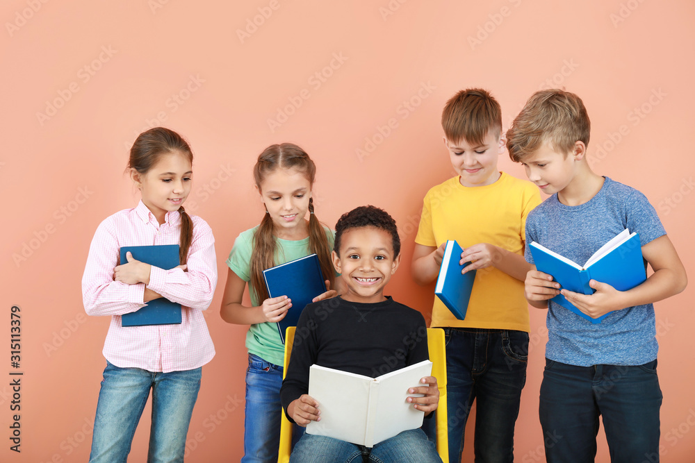 Cute little children with books on color background