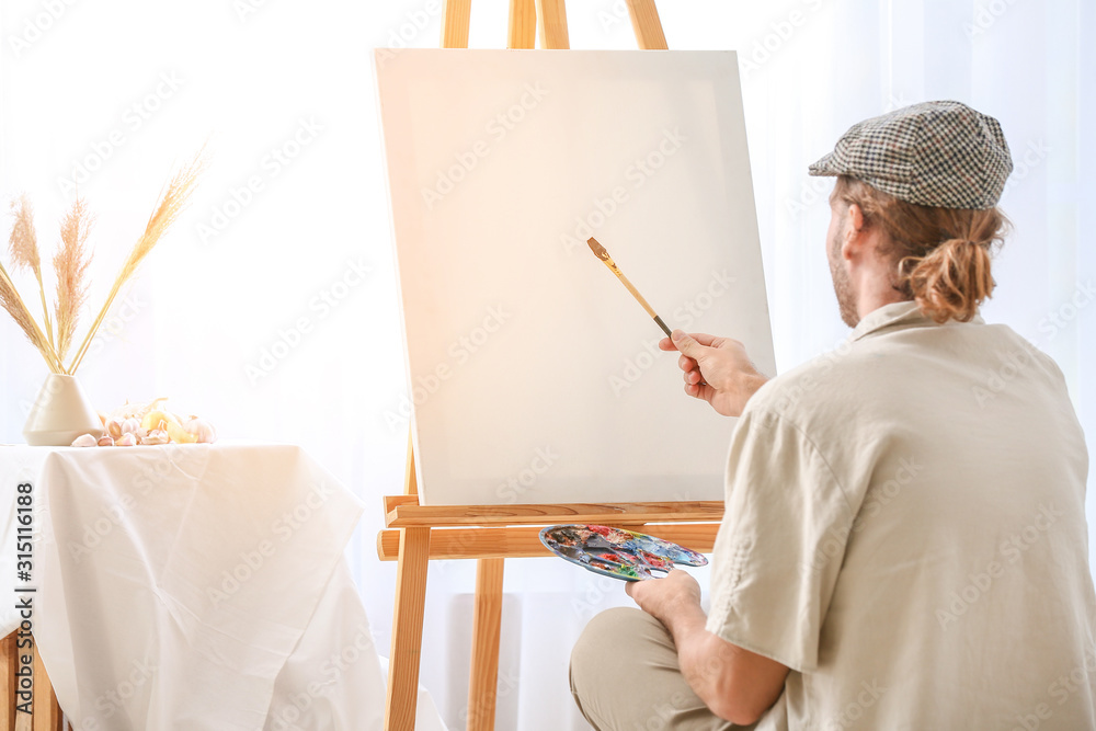 Young male artist working in studio