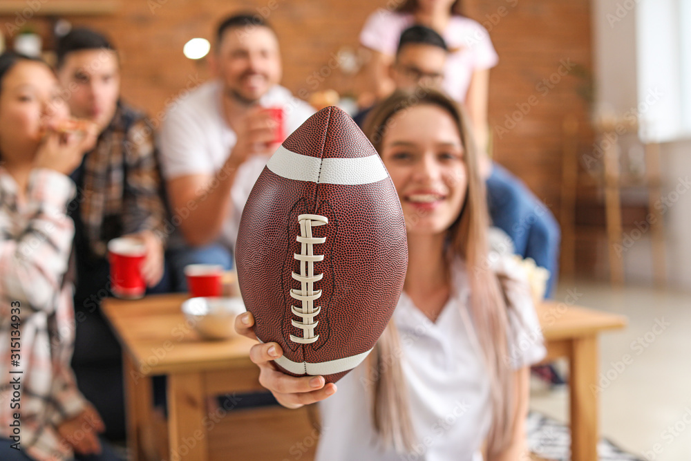 Young woman with friends watching rugby on TV