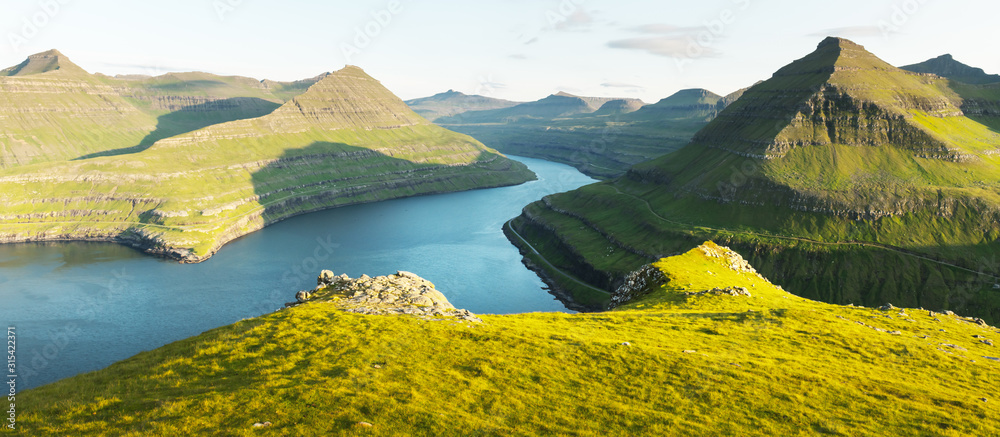 法罗群岛埃伊斯图罗伊岛丰宁格尔阳光明媚的峡湾全景。风景照片