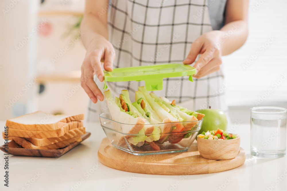 妈妈在家里厨房为女儿准备学校零食或午餐