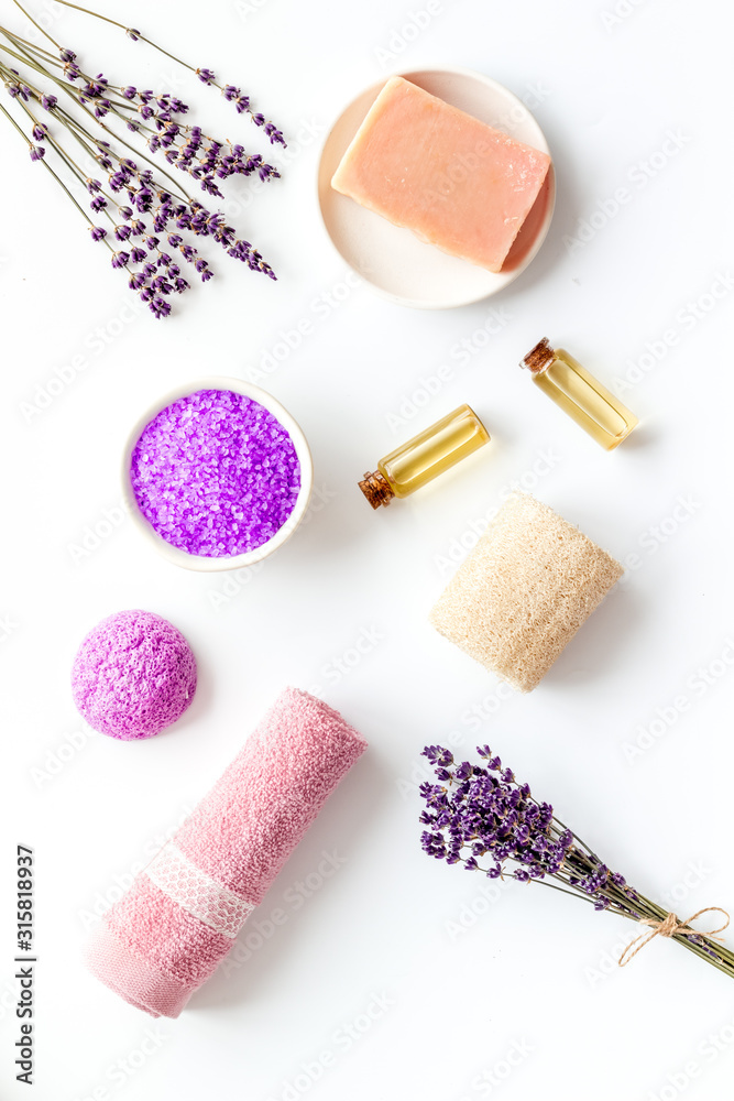 Lavender spa set. Violet bath salt, soap, essence oil on white background top-down