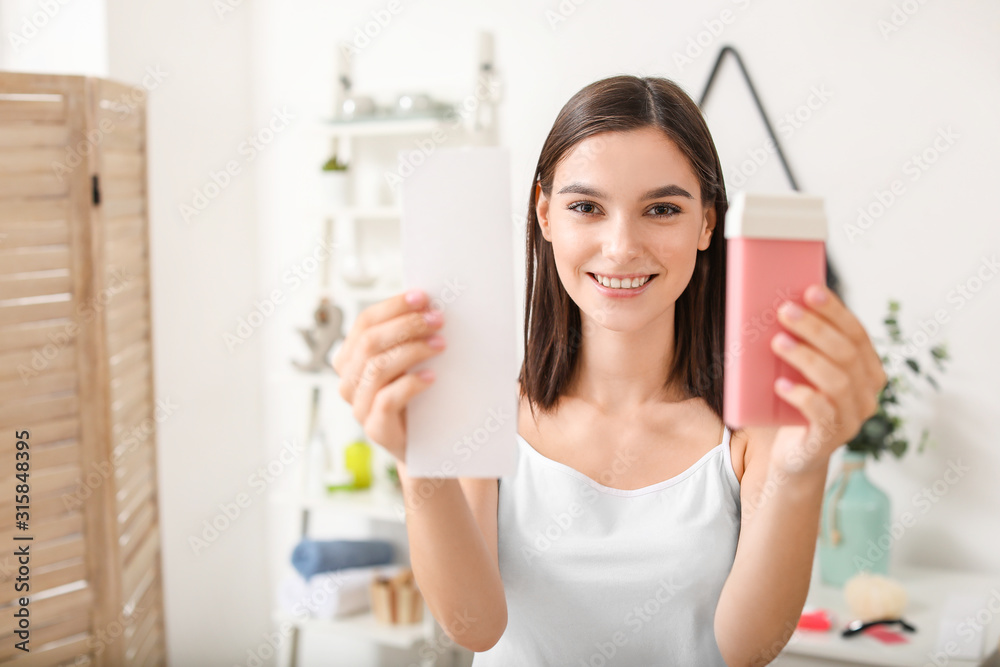 浴室里有脂溶性蜡筒的漂亮年轻女人