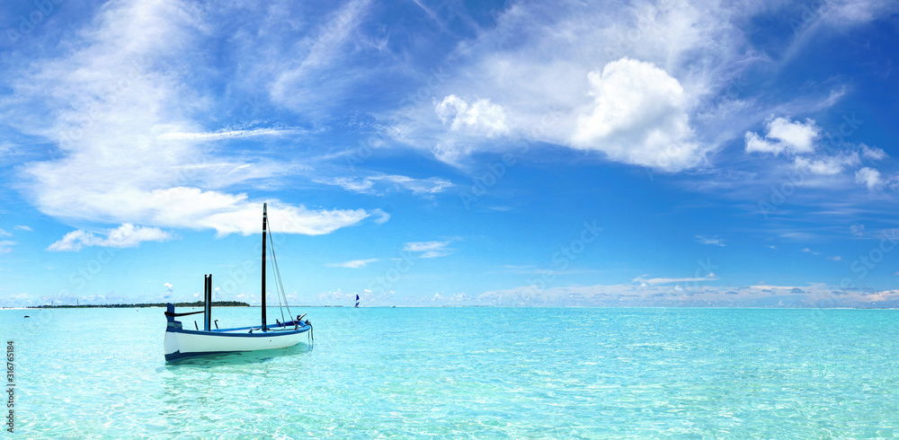 在碧绿的海水中划船，蓝天白云。夏季度假的自然景观