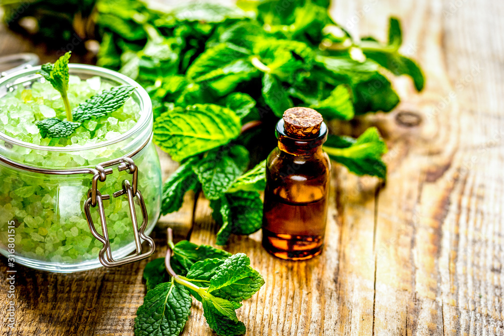 organic cosmetics with herbal extracts of mint on wooden background