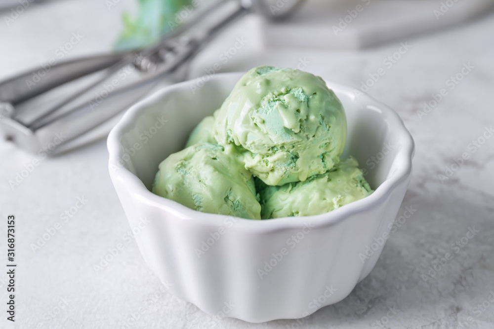 Tasty ice-cream in bowl on white table