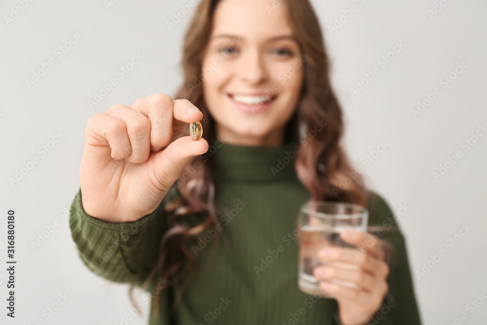 浅背景下有鱼油的年轻女性，特写