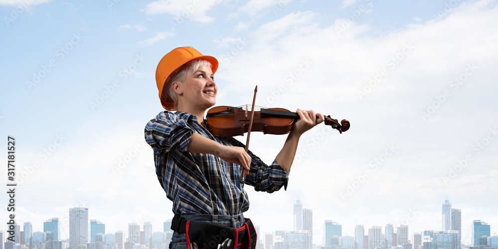 Beautiful woman in safety helmet playing violin