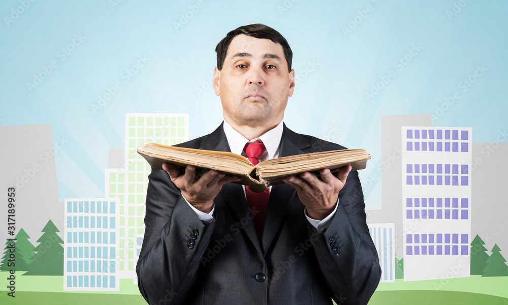 Serious businessman holding open book