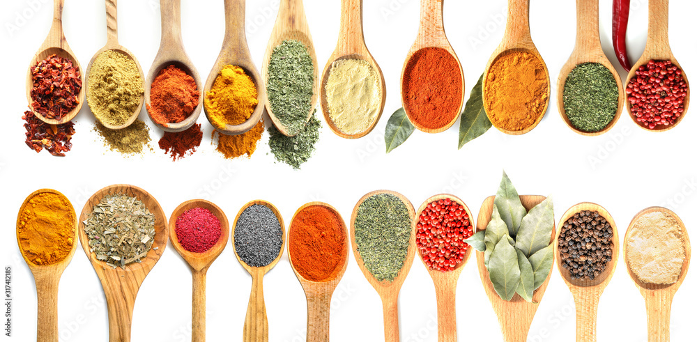 Many wooden spoons with various spices on white background