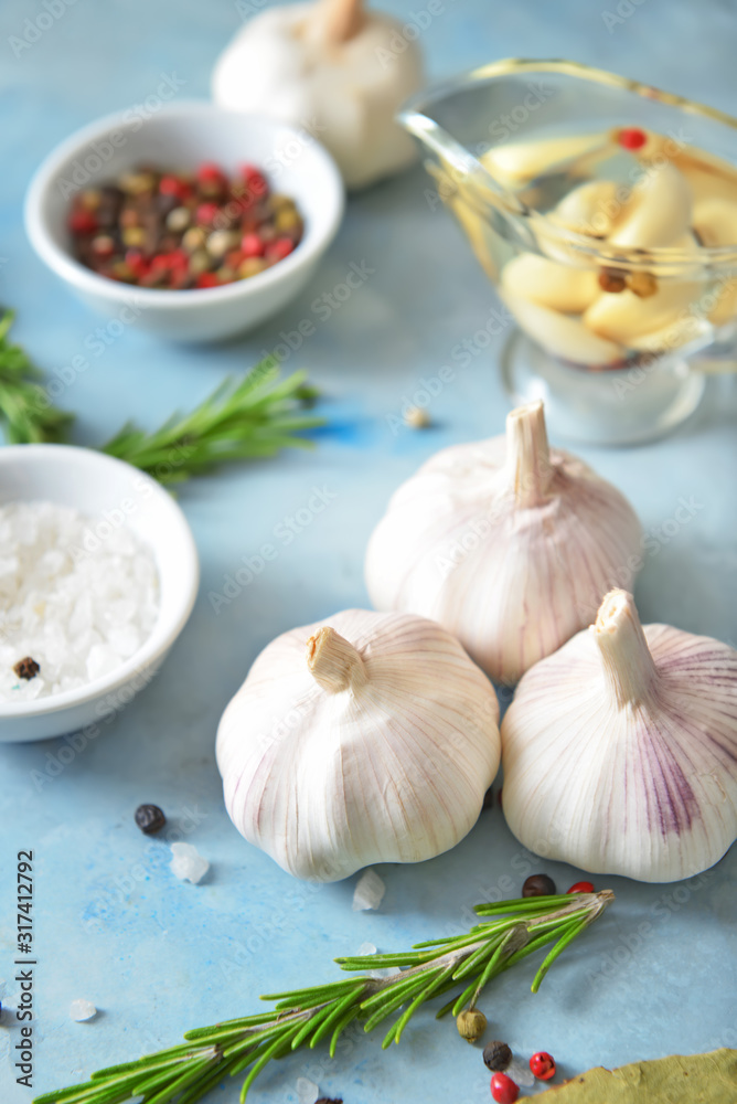 Fresh garlic with spices and herbs on color background