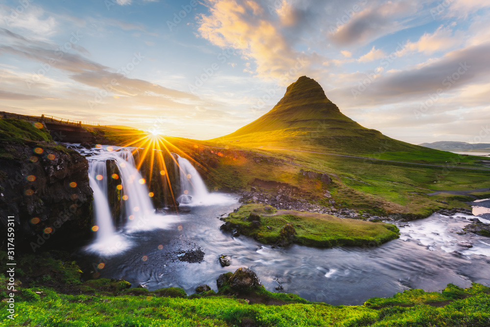 Morning landscape with rising sun on Kirkjufellsfoss waterfall and Kirkjufell mountain, Iceland, Eur