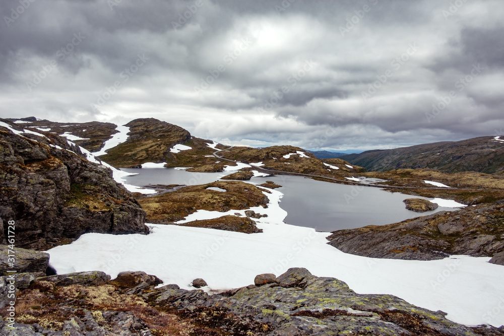 Typical norwegian landscape with snowy mountains and clear lake near the famous Aurlandsvegen (Bjorg